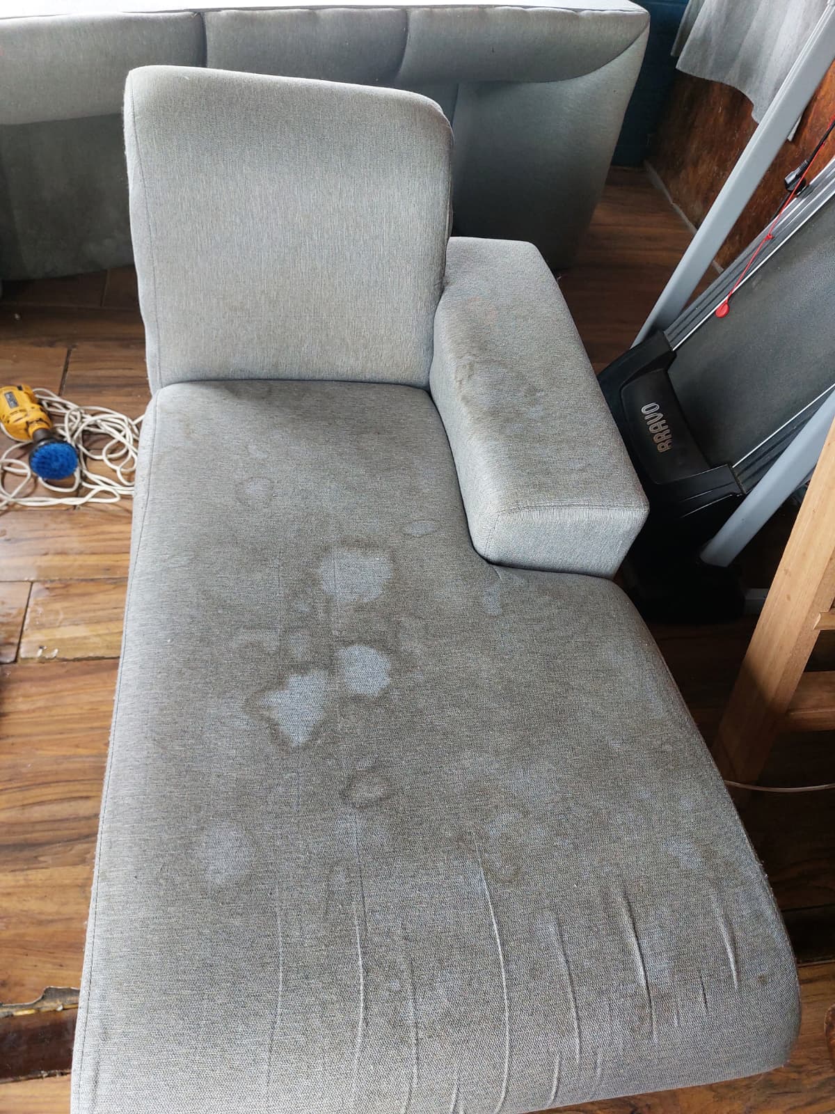 Chaise longue gris antes de la limpieza, con manchas en el asiento